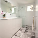 Bathroom with grey wall tiles and black pattern tile floors