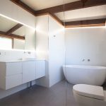 White tile bathroom with bathtub and toilet