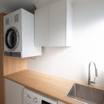 White laundry with wooden counter and cupboard