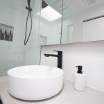 White tile bathroom with stone counter sink