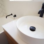 White bathroom with black faucets and taps