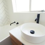 White bathroom with black faucets